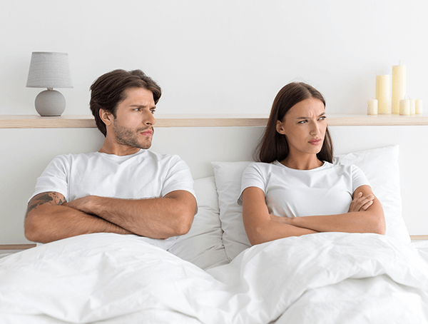 photo of an unhappy married couple in bed